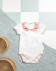 Body bébé col imprimé Bandia vu de face, avec des motifs africains élégants et un tissu en coton doux