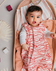 Bébé confortablement installé dans un panier en rotin, portant la gigoteuse bébé été imprimée Bandia de Bobo Bassari, légère et adaptée aux nuits d’été