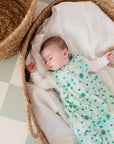 Bébé allongé dans un panier en rotin, habillé de la gigoteuse bébé été imprimée Samé de Bobo Bassari, conçue pour un confort optimal pendant les nuits d’été