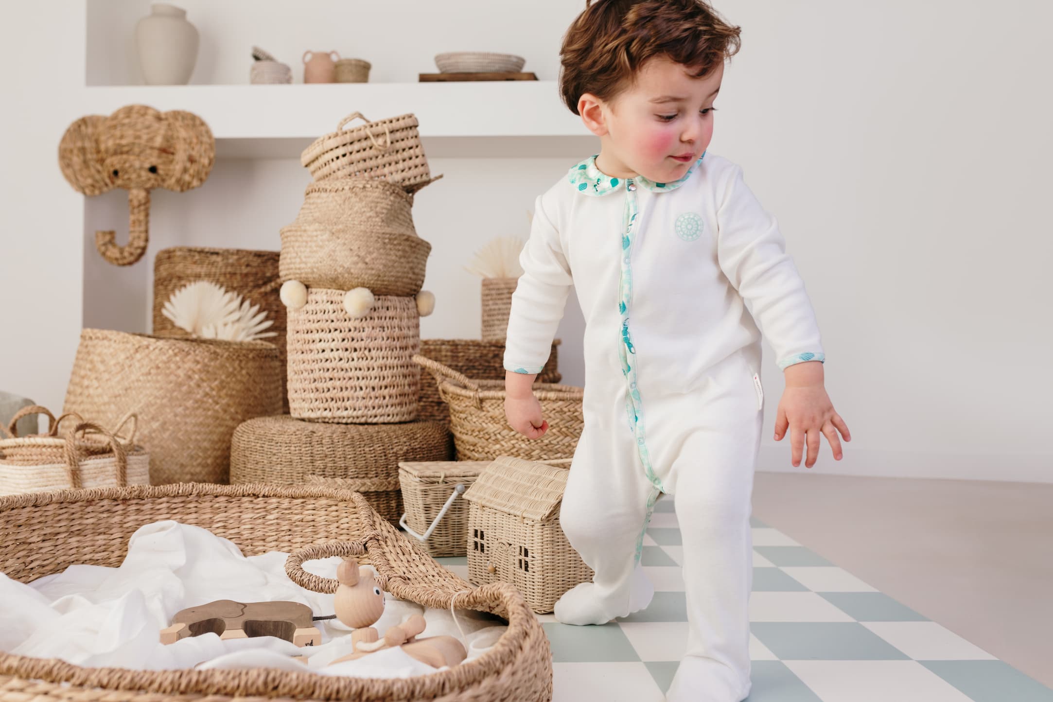 Un enfant en train de se lever, portant le pyjama bébé été col imprimé Samé de Bobo Bassari, avec des motifs vibrants et un design confortable