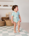 Enfant debout portant le body bébé imprimé "Samé", design coloré et confortable, parfait pour les bébés de 0 à 36 mois